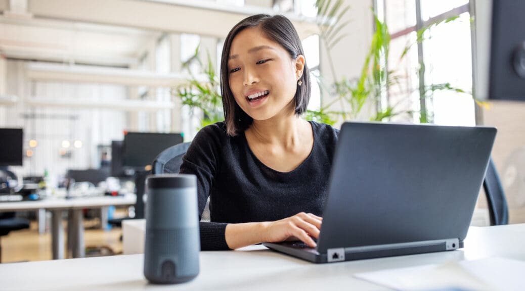 Female professional using virtual assistant at desk