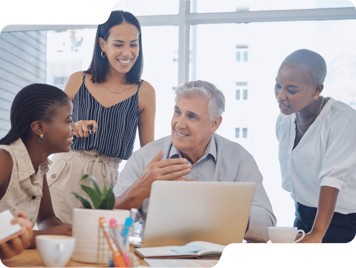 Several colleagues gathered around a laptop.