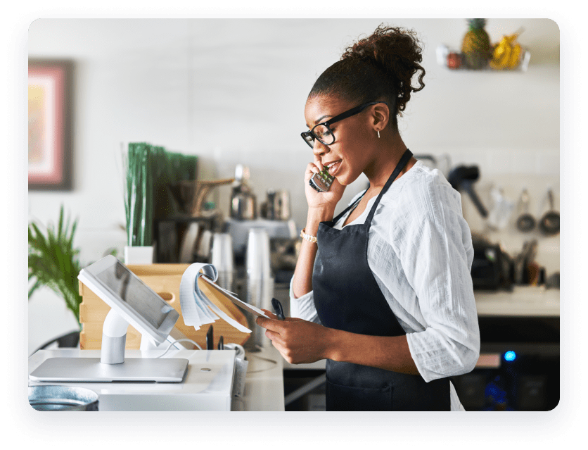 Woman at restaurant on the phone looking at notepad