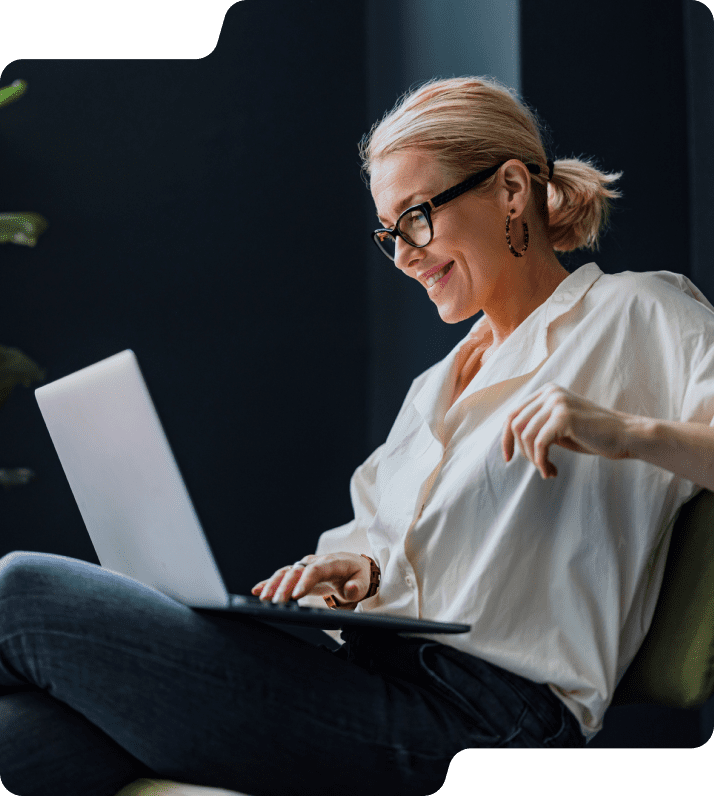 Woman on laptop smiling.