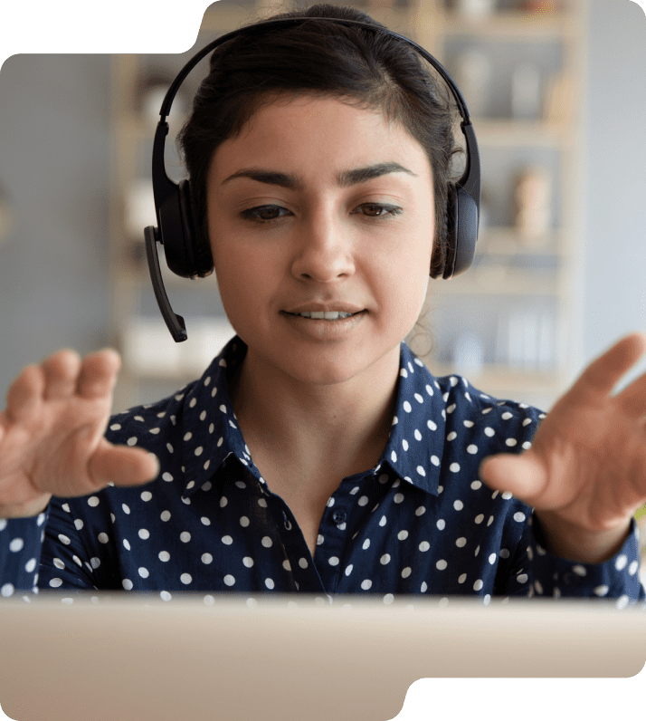 Woman on headset in front of computer.