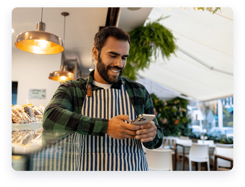 Man at cafe holding phone.