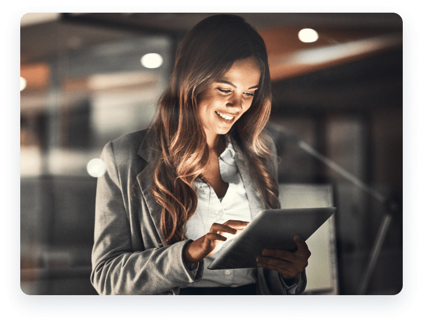 Woman smiling holding tablet.