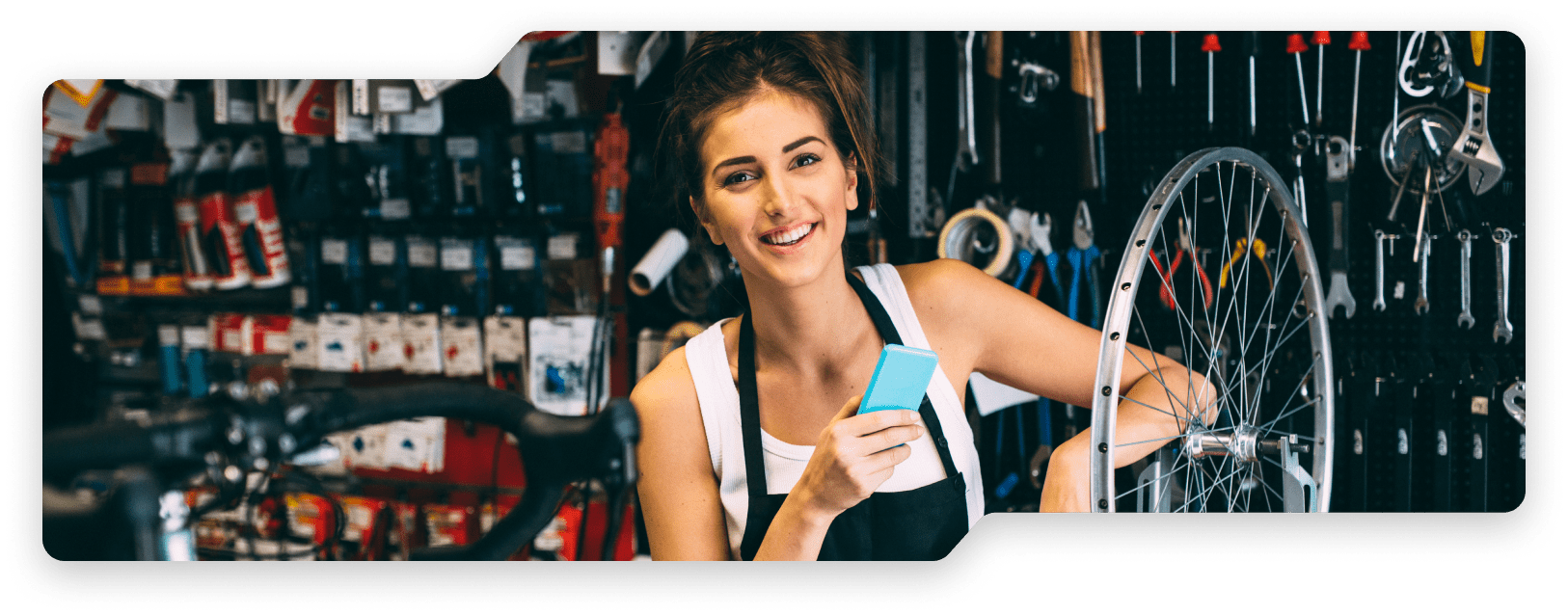 Woman holding phone at a bike shop.
