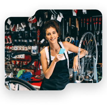 Woman holding phone at a bike shop.