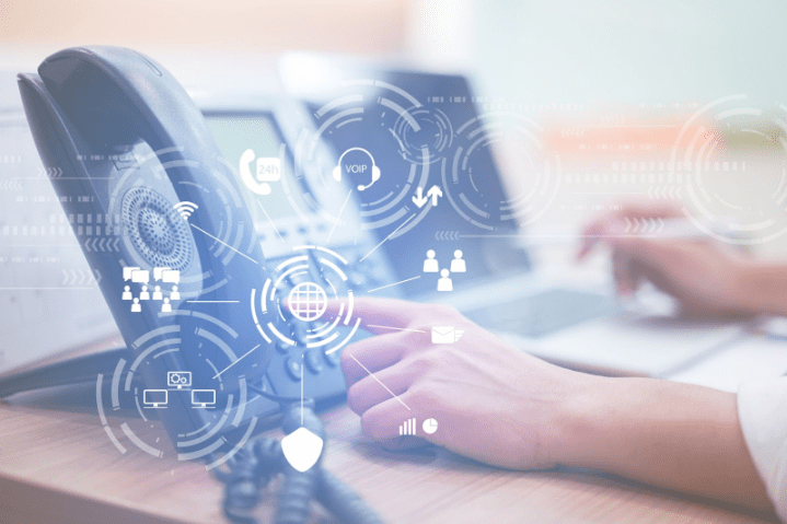Close-up of a VoIP desk phone with digital communication icons overlay, representing a modern PBX system in a business setting.