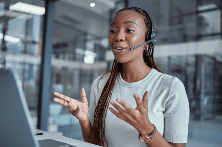 A professional woman wearing a headset, engaging in a VoIP call from a modern office. Represents seamless business communication using VoIP technology.