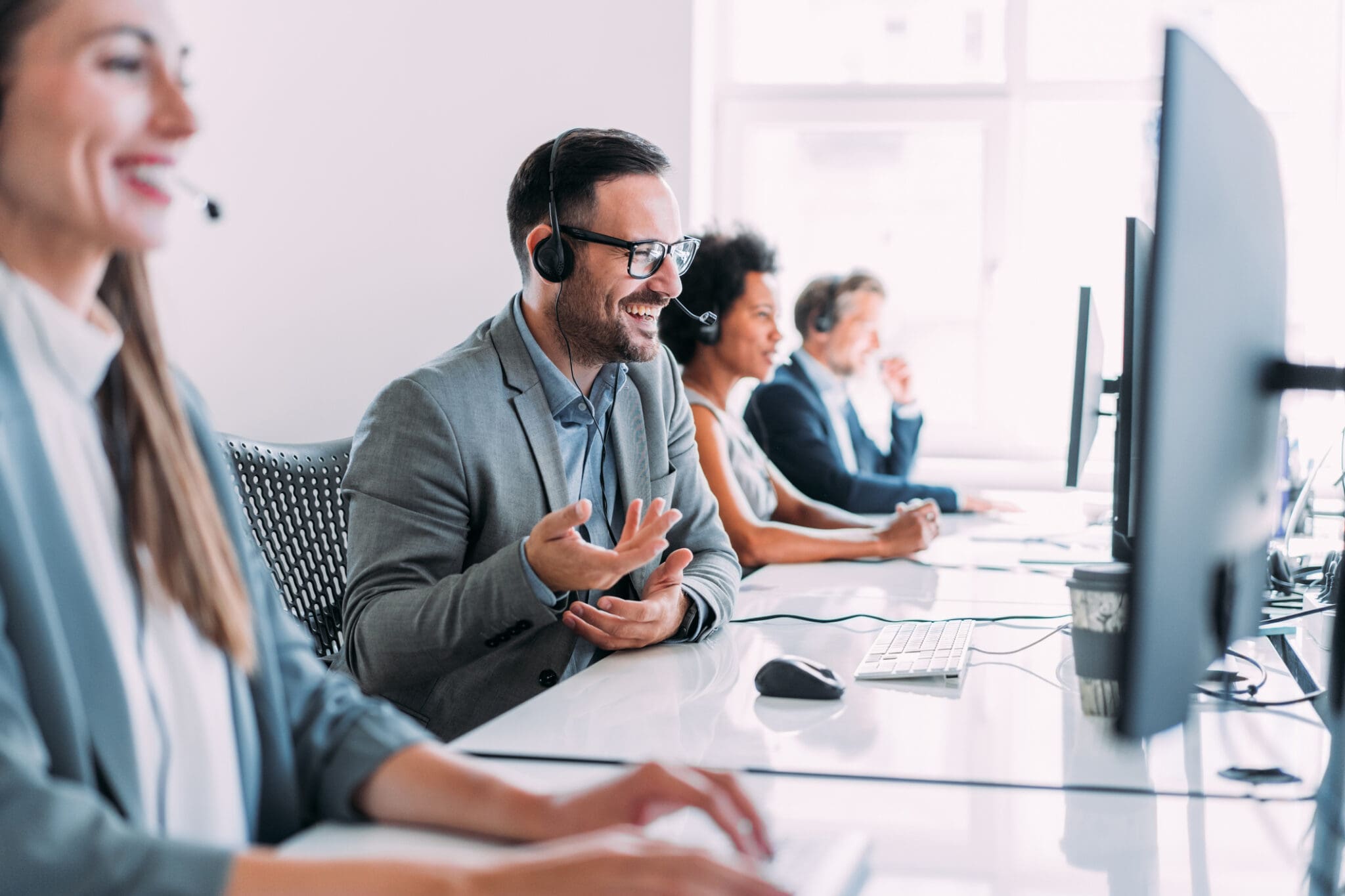 Smiling business professionals using VoIP headsets in a modern office, ensuring seamless customer support